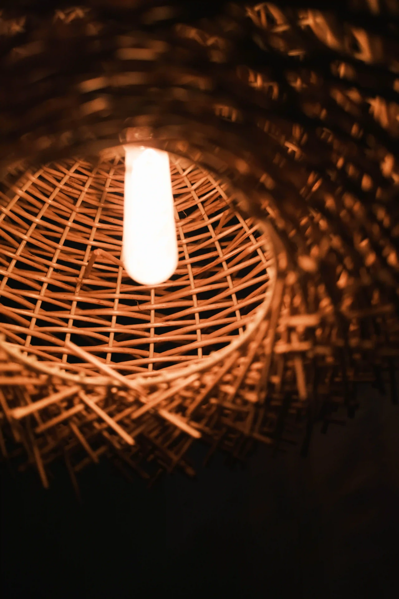 Warm light glowing through a woven rattan pendant lamp